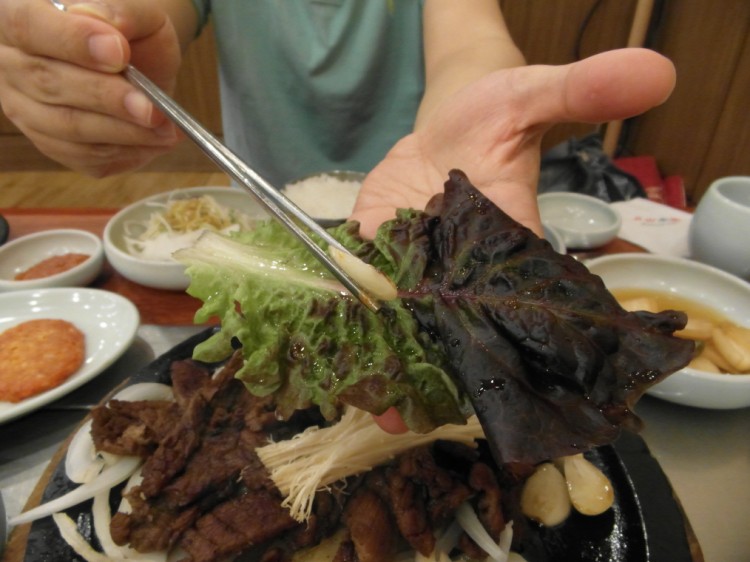 広げたレタスの上に焼いたニンニクを入れて下さい。ニンニクは肉と一緒に出されますが、焼くのはご自分でしなきゃならないです。韓国人の中には生で食べるひとも結構多いからです。